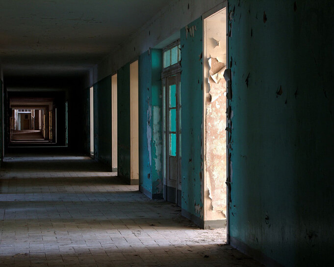 Empty doors inside a building at the Hohenlychen clinic. Source.