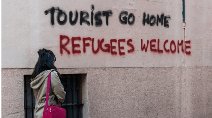Eine mallorquinische Bürgerinitiative fordert auf Wänden in Palma: "Tourist go home. Refugees welcome". Tourist geh nach Hause. Flüchtlinge willkommen. (Foto: dpa)