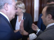 Ein Mitarbeiter von Großmufti Scheich Abdel-Latif Derian versucht, Marine Le Pen ein weißes Kopftuch zu übergeben. (Screenshot: YouTube)