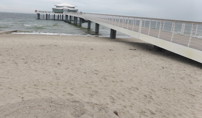 Der Timmendorfer Strand mit dem Teehaus von Mäzen Jürgen Hunke (Gründer des Allfinanzvertriebes Zeus, Ex-HSV-Präsident, Besitzer der Hamburger Kammerspiele und der Hamburger Trabrennbahn, das aber nach einem Bürgerentscheid nun das Restaurant Wolkenlos von Gastronom Christian Kermel beherbergt) ragt 275 Meter tief in die Ostsee, die so geschützt ist, dass sie gar keine natürliche Brandung aufweist. Nur Sturm sorgt für Hochwasser (Foto: Berlin Journal)